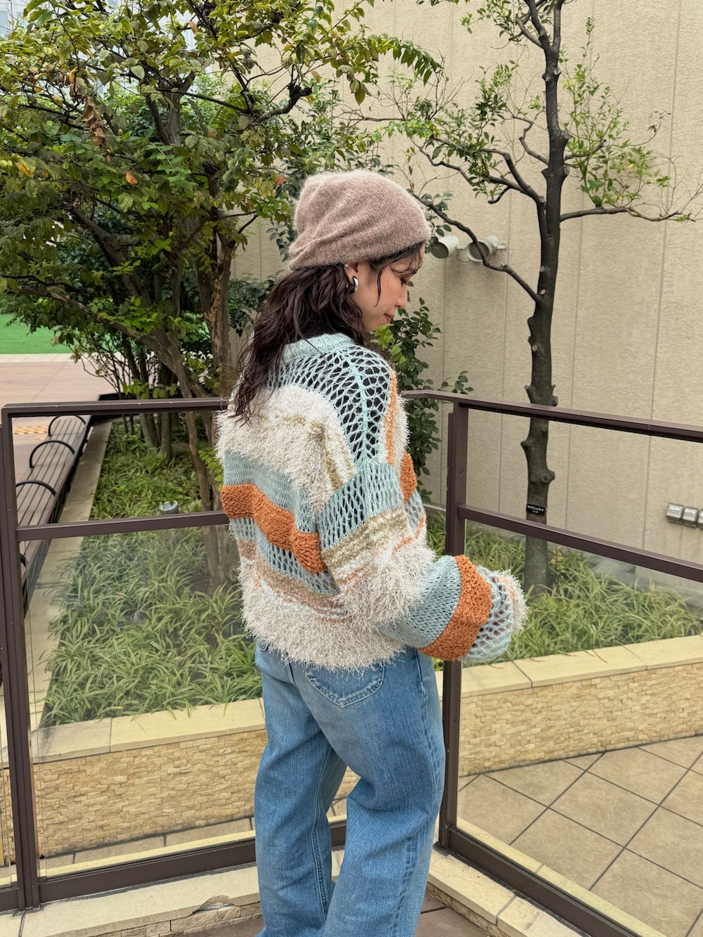 ブルー系のニット/セーター、ブラック系のTシャツ/カットソー、ブルー系のデニムパンツを着用したレディースの秋コーディネートの10枚目の写真