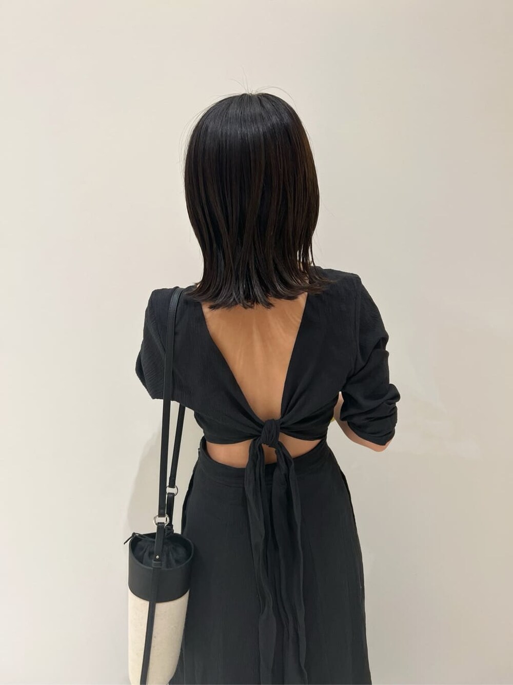 ブラック系のワンピース、ブラック系のショルダーバッグ、ブラック系のサンダルを着用したレディースの春コーディネートの5枚目の写真