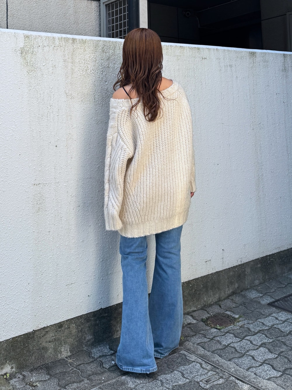 ホワイト系のニット/セーター、ブルー系のデニムパンツ、シルバー系のその他シューズを着用したレディースの夏コーディネートの4枚目の写真