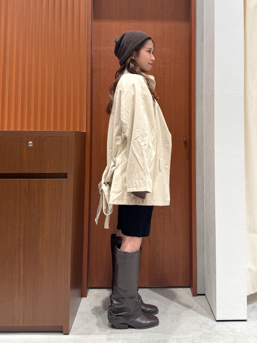 ベージュ系のトレンチコート、ブラウン系のスウェット、ブラック系のその他パンツを着用したレディースの秋コーディネートの2枚目の写真