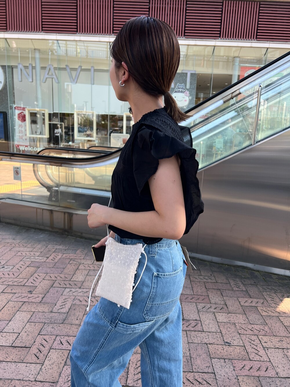 ブルー系のデニムパンツ、ブラック系のパンプス、ブラック系のシャツ/ブラウスを着用したレディースの春コーディネートの5枚目の写真