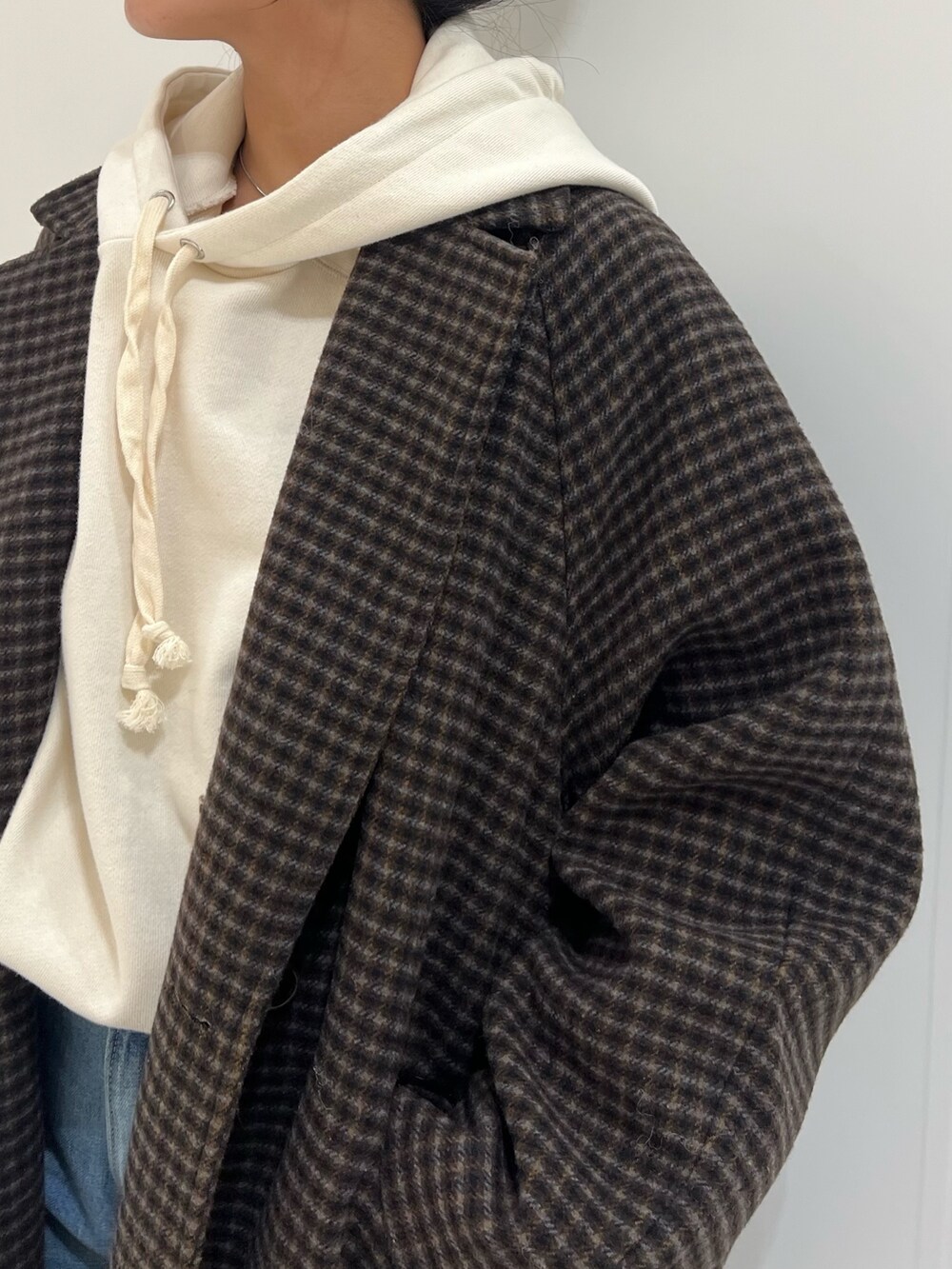 ベージュ系のブーツ、ブルー系のデニムパンツ、その他のチェスターコートを着用したレディースの冬コーディネートの9枚目の写真