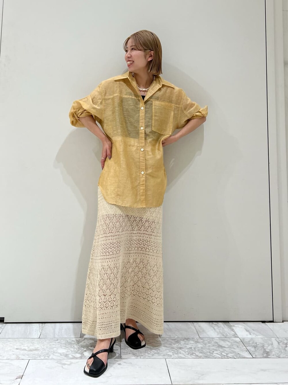 ブラウン系のシャツ/ブラウス、ベージュ系のスカート、ブラック系のサンダルを着用したレディースの春コーディネートの3枚目の写真