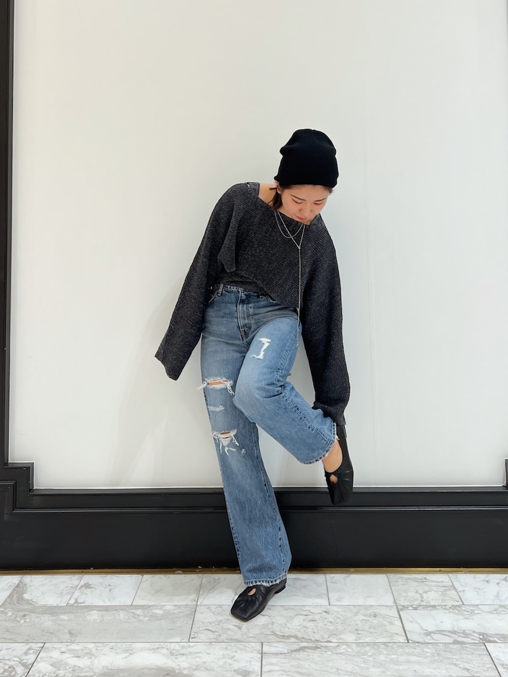 ブルー系のデニムパンツ、グレー系のニット/セーター、ブラック系のパンプスを着用したレディースの春コーディネートの2枚目の写真