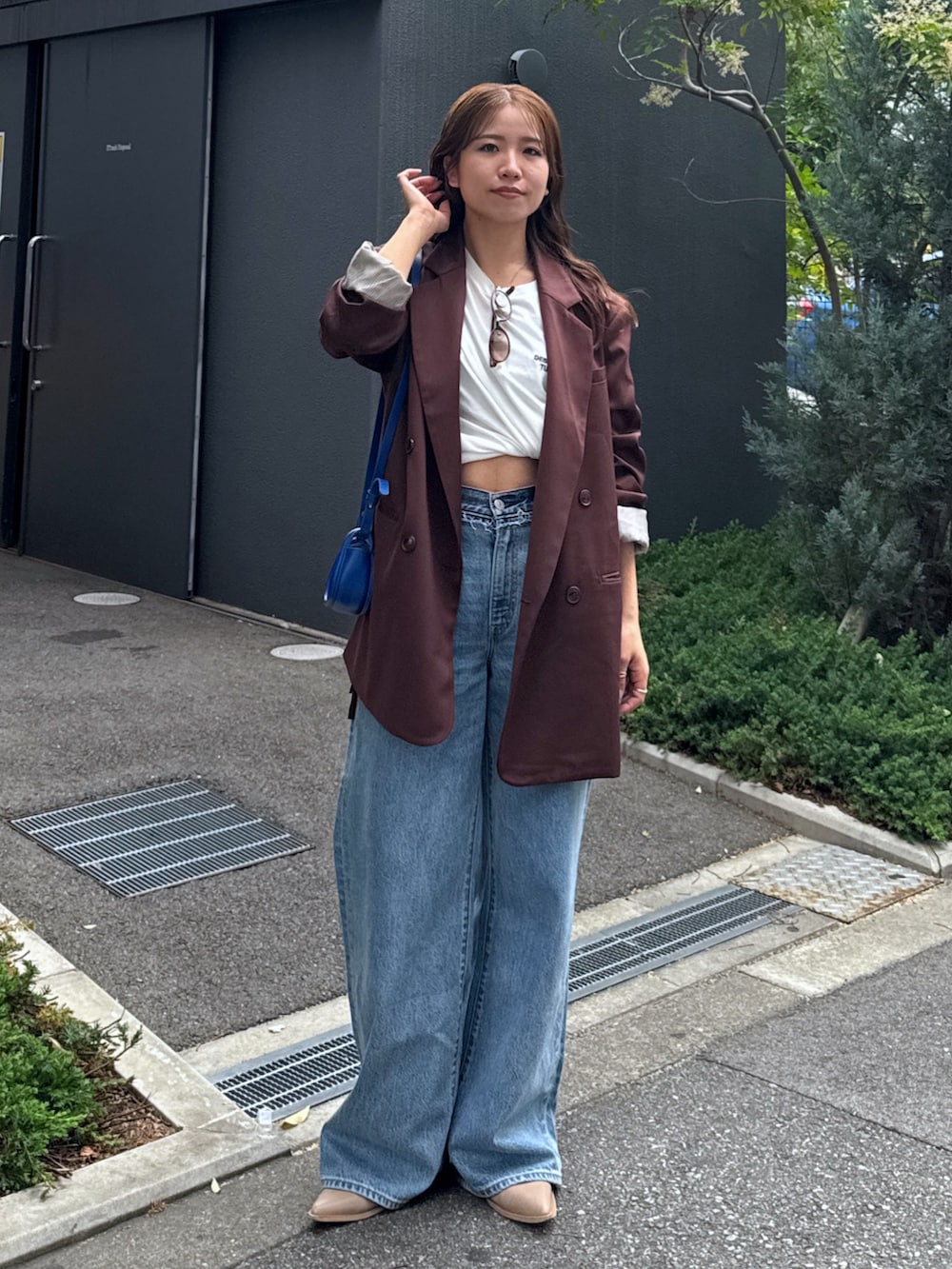 ブルー系のデニムパンツ、ブラウン系のテーラードジャケット、ホワイト系のTシャツ/カットソーを着用したレディースの夏コーディネートの2枚目の写真