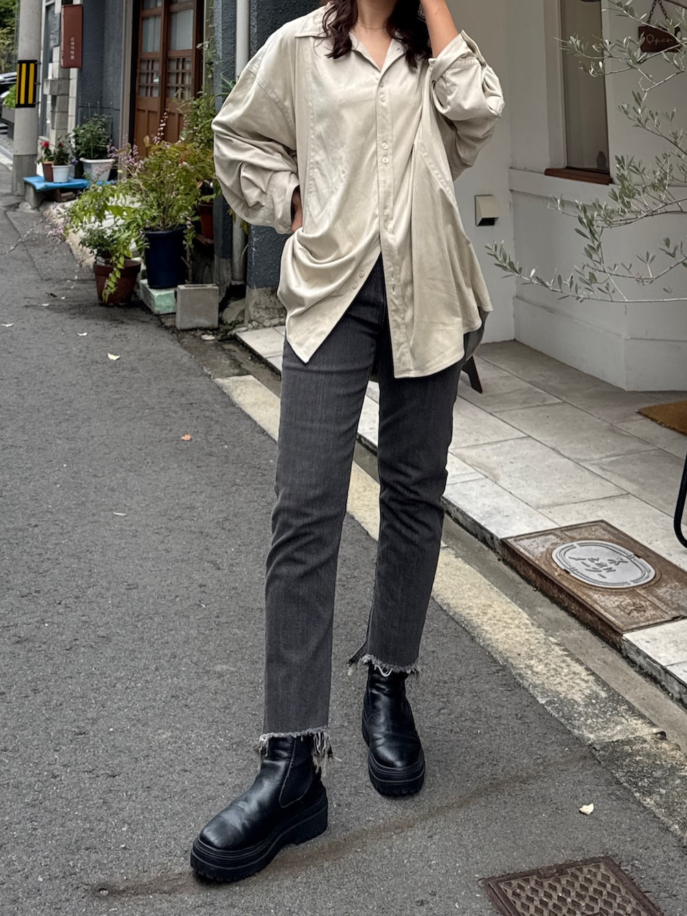 ブラック系のデニムパンツ、ホワイト系のシャツ/ブラウスを着用したレディースの秋コーディネートの2枚目の写真