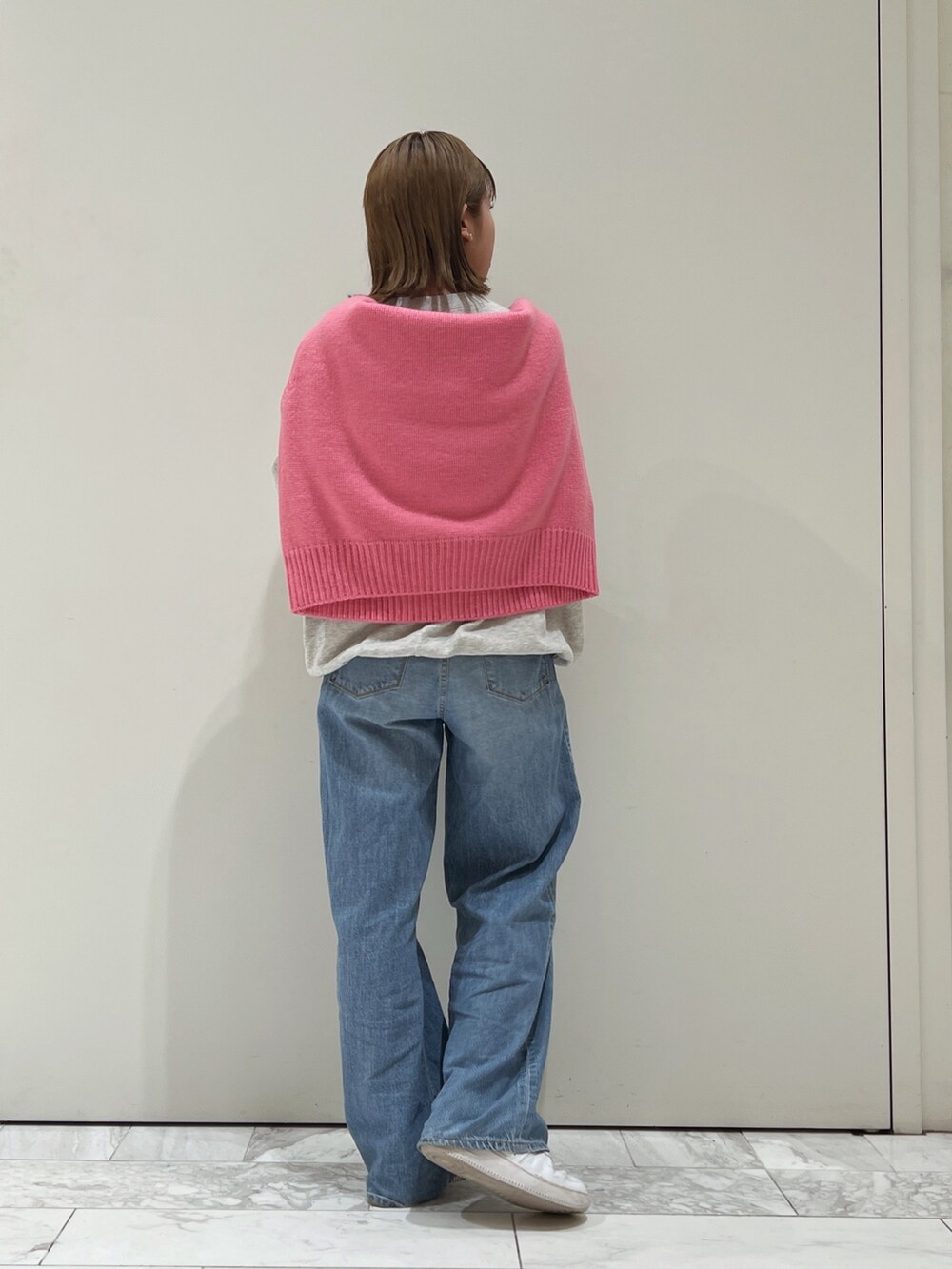 ピンク系のニット/セーター、グレー系のスウェット、ブルー系のデニムパンツを着用したレディースの秋コーディネートの4枚目の写真