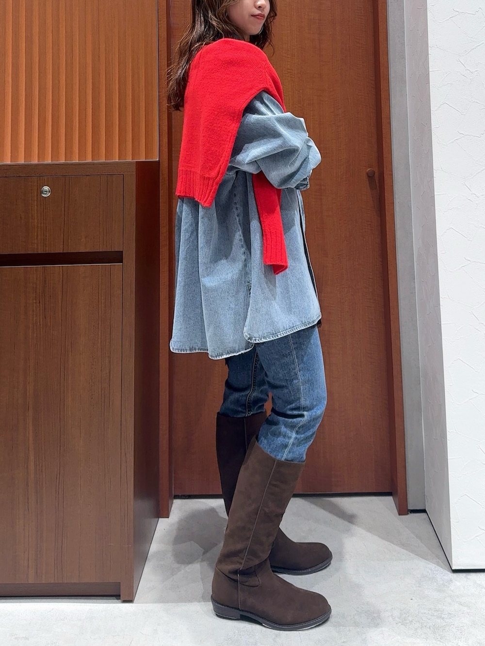 ブルー系のシャツ/ブラウス、レッド系のニット/セーター、ブラック系のキャミソールを着用したレディースの冬コーディネートの3枚目の写真