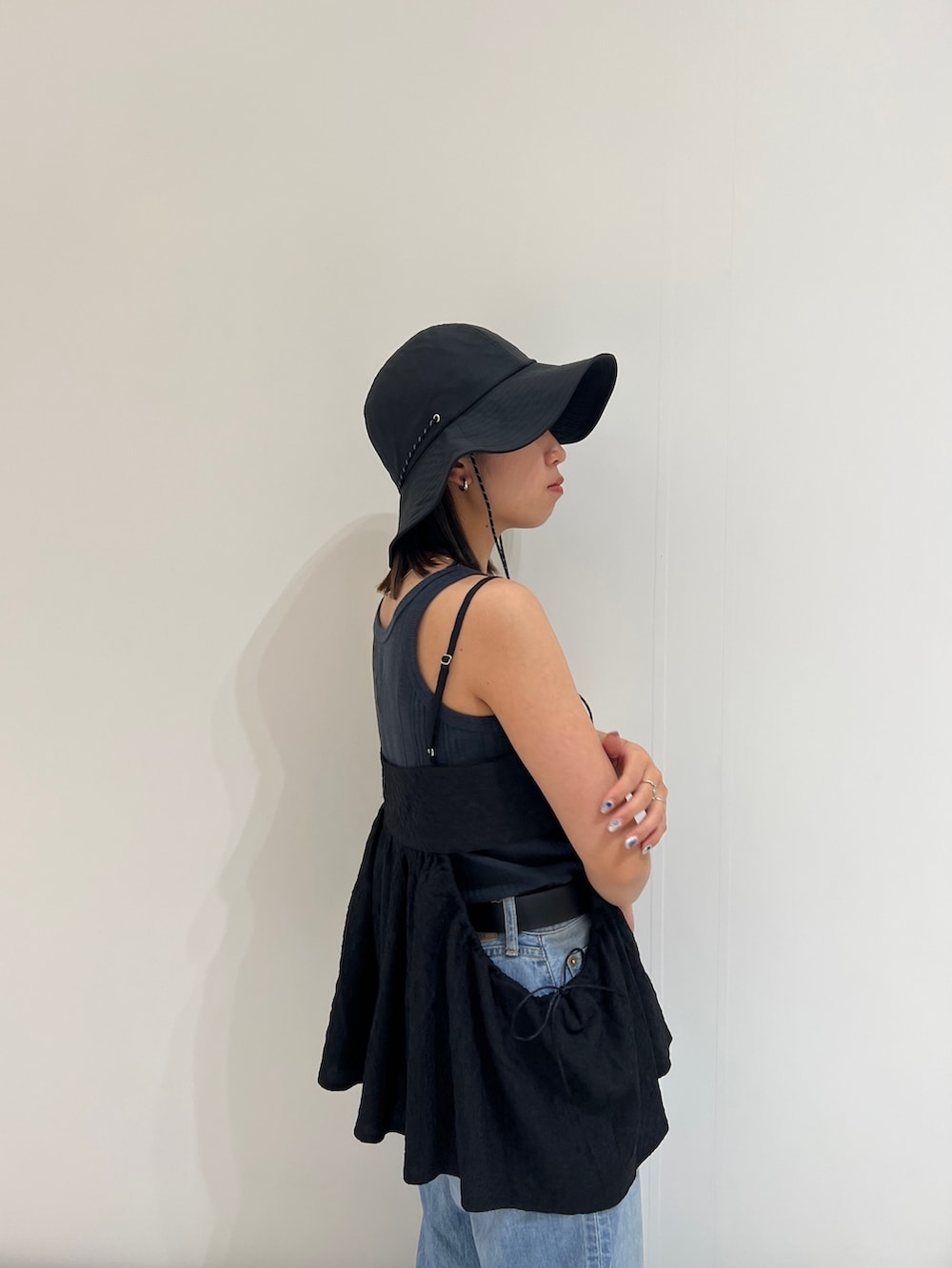 グレー系のタンクトップ、ブルー系のデニムパンツ、ブラック系のシャツ/ブラウスを着用したレディースの春コーディネートの8枚目の写真