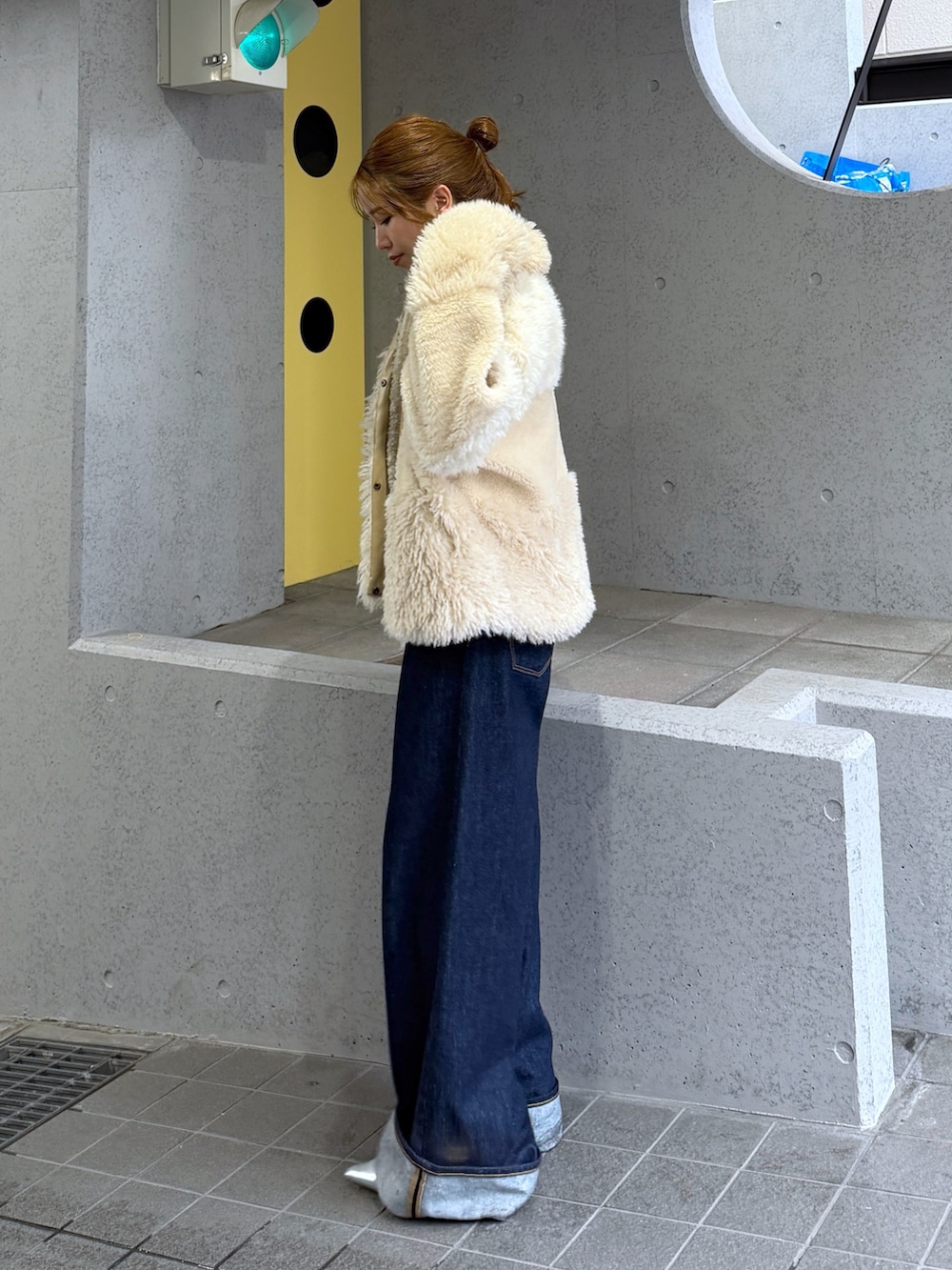 ホワイト系のブルゾン、シルバー系のパンプス、ブルー系のデニムパンツを着用したレディースの秋コーディネートの8枚目の写真