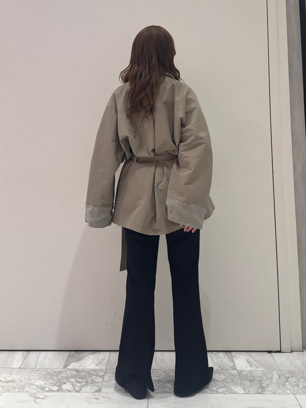 グリーン系のトレンチコート、ブラック系のその他パンツ、ブラック系のパンプスを着用したレディースの春コーディネートの5枚目の写真