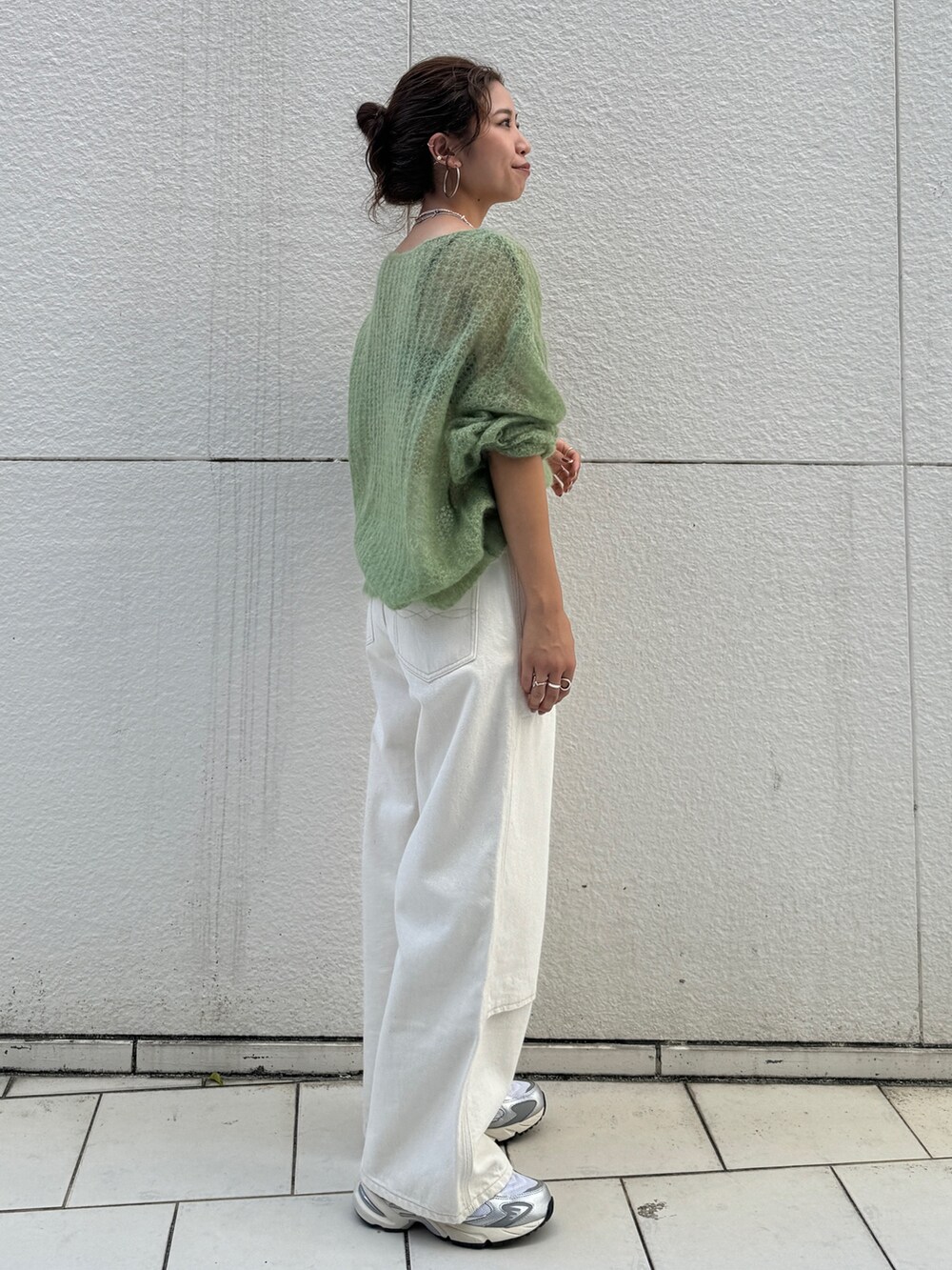 ホワイト系のデニムパンツ、グリーン系のニット/セーターを着用したレディースの秋コーディネートの3枚目の写真