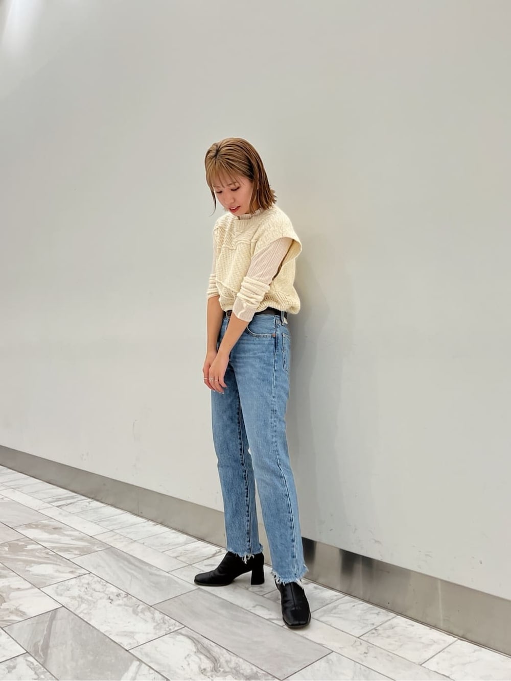 ブラック系のブーツ、ホワイト系のニット/セーター、ホワイト系のニット/セーターを着用したレディースの夏コーディネートの3枚目の写真