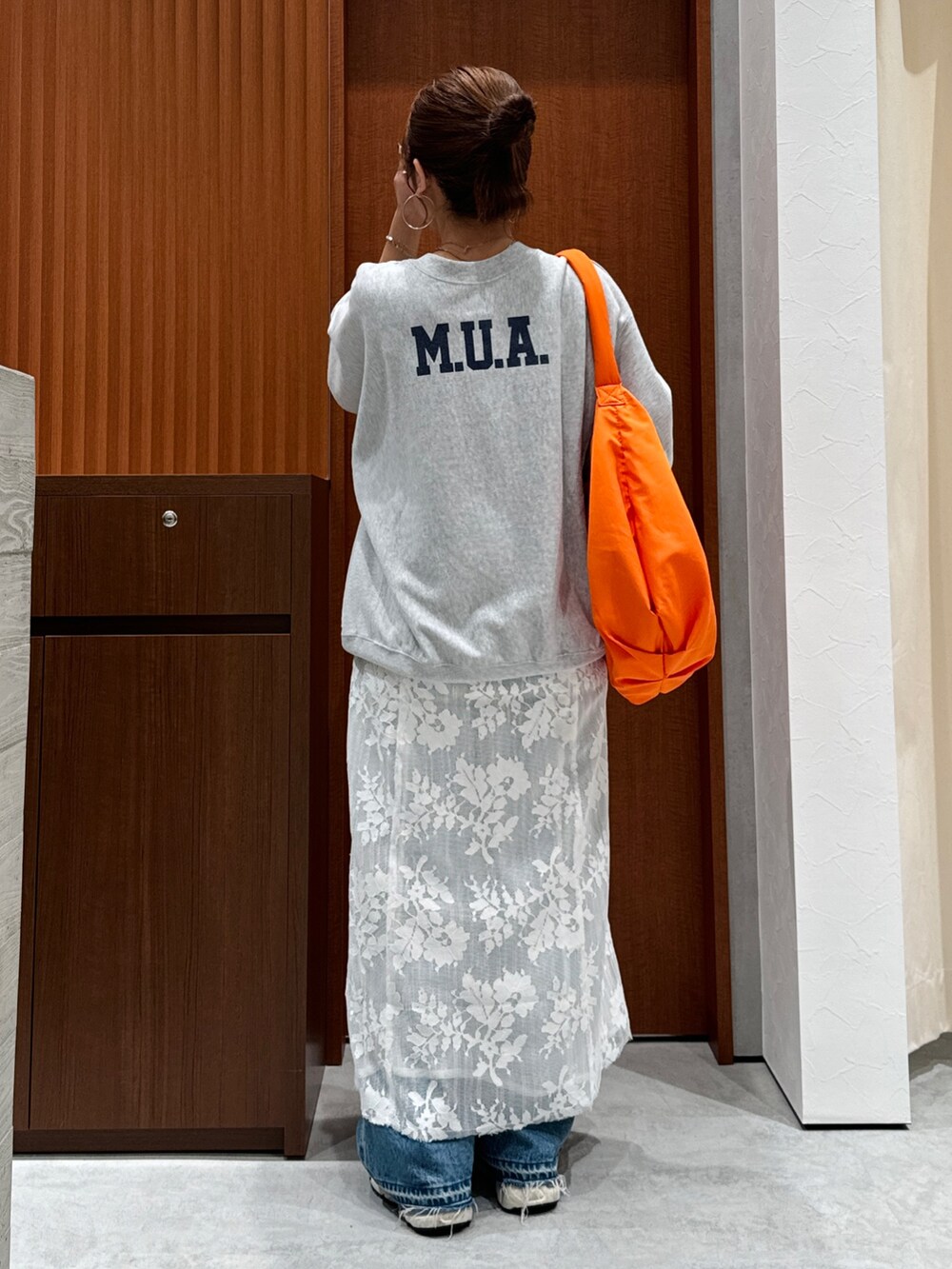 ホワイト系のワンピース、グレー系のスウェット、ブルー系のデニムパンツを着用したレディースの秋コーディネートの4枚目の写真