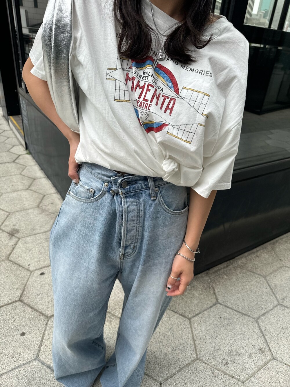 ブルー系のデニムパンツ、ホワイト系のTシャツ/カットソー、シルバー系のハンドバッグを着用したレディースの春コーディネートの7枚目の写真