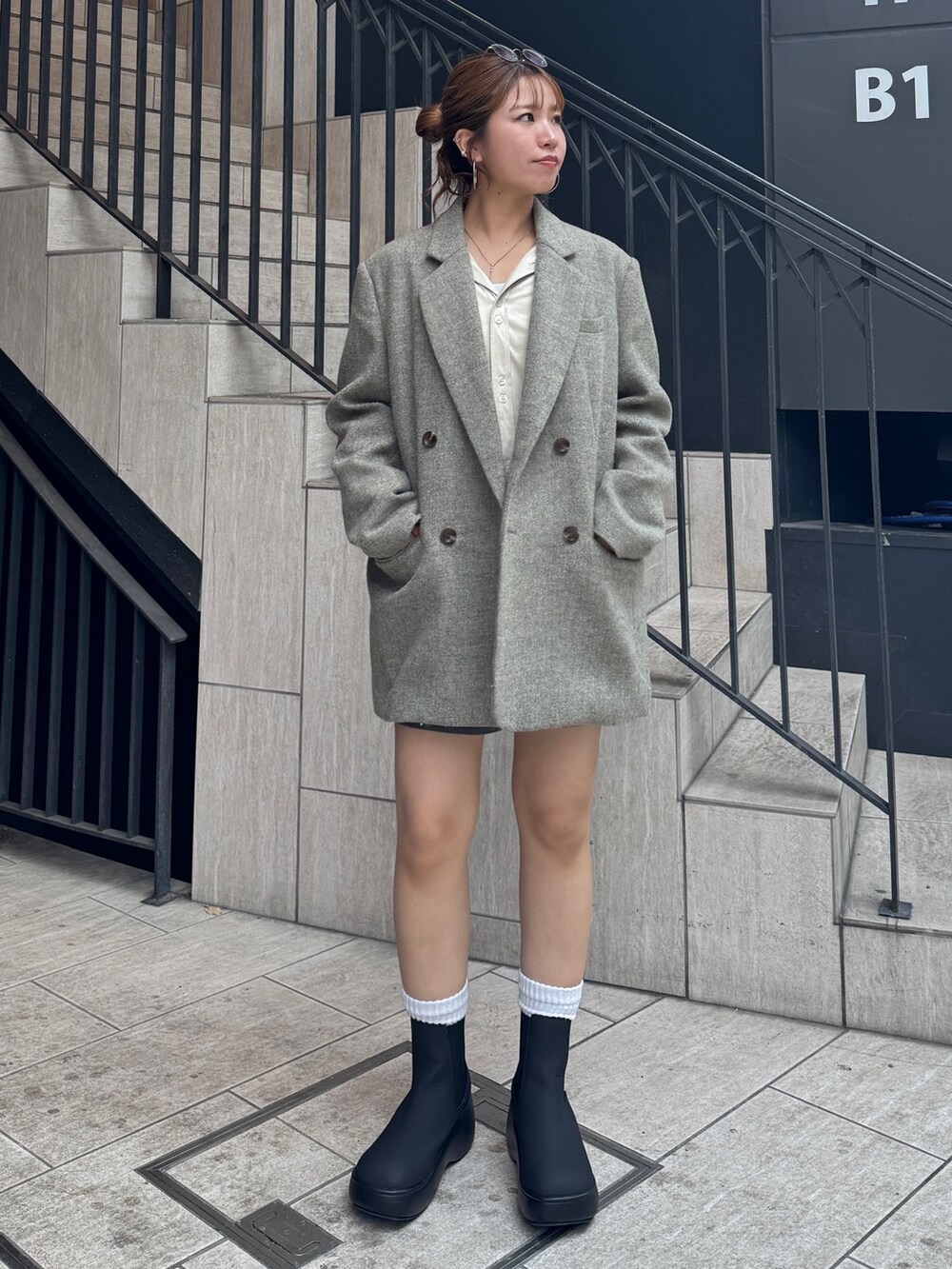 グレー系のスカート、ホワイト系のシャツ/ブラウス、グレー系のテーラードジャケットを着用したレディースの秋コーディネートの6枚目の写真