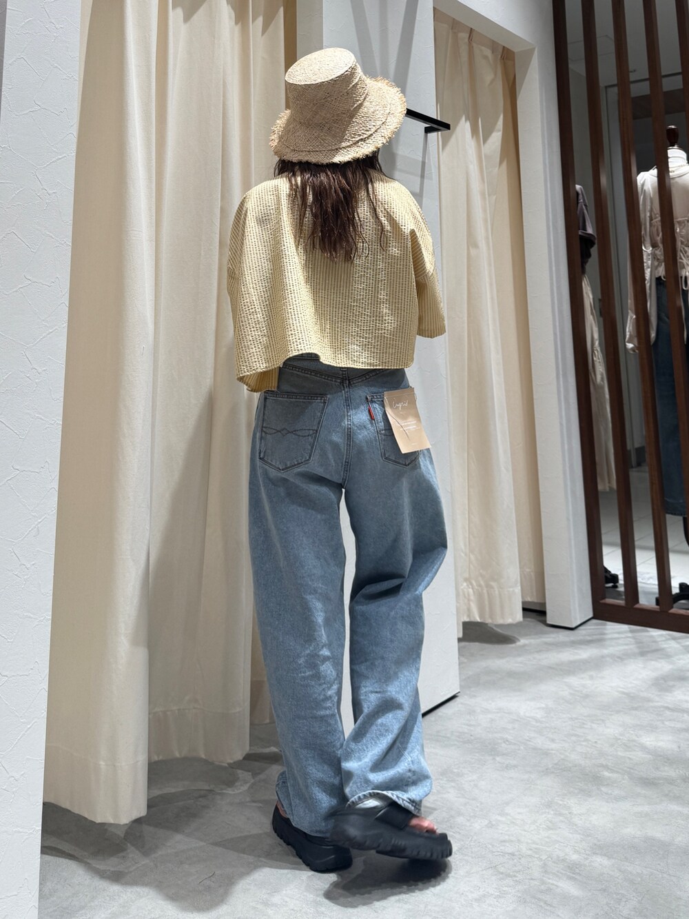 イエロー系のシャツ/ブラウス、ブルー系のデニムパンツ、ベージュ系のハットを着用したレディースの春コーディネートの6枚目の写真