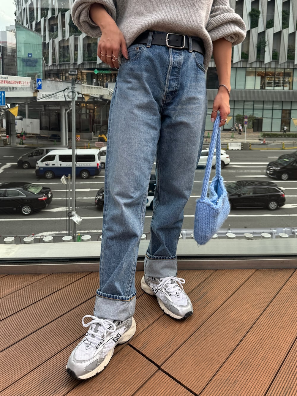 ブルー系のハンドバッグ、グレー系のニット/セーター、ブルー系のデニムパンツを着用したレディースの秋コーディネートの9枚目の写真