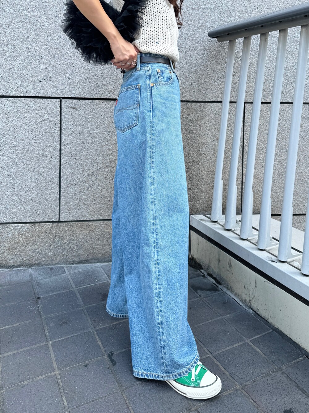 ブルー系のデニムパンツ、ホワイト系のニット/セーター、ブラック系のショルダーバッグを着用したレディースの秋コーディネートの10枚目の写真