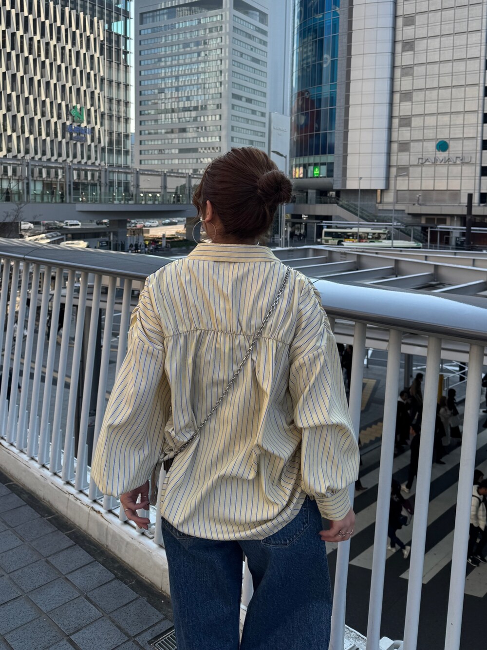 イエロー系のシャツ/ブラウス、ブルー系のデニムパンツ、ブラウン系のローファーを着用したレディースの冬コーディネートの5枚目の写真