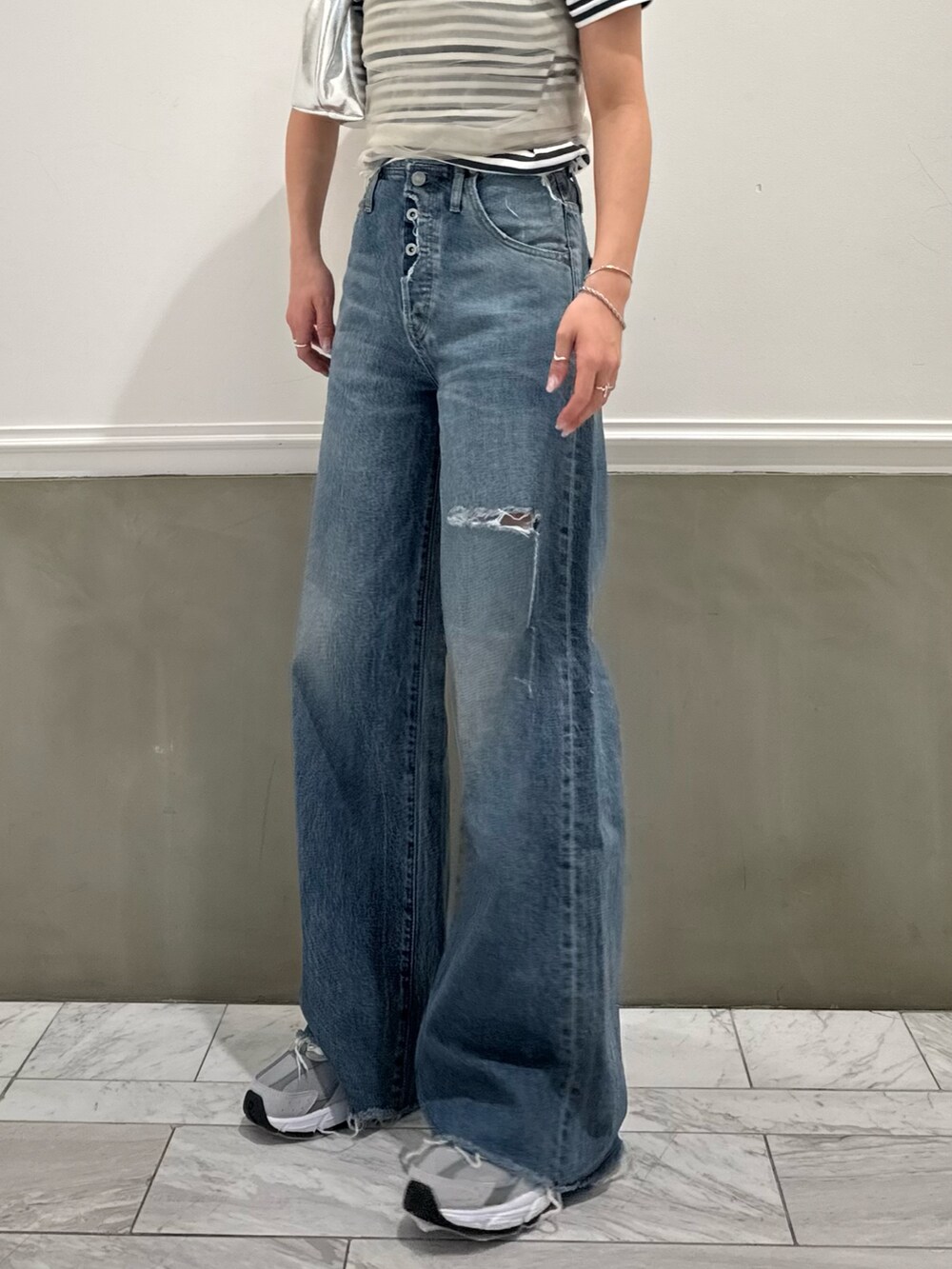 グレー系のTシャツ/カットソー、ベージュ系のキャミソール、ブルー系のデニムパンツを着用したレディースの春コーディネートの5枚目の写真