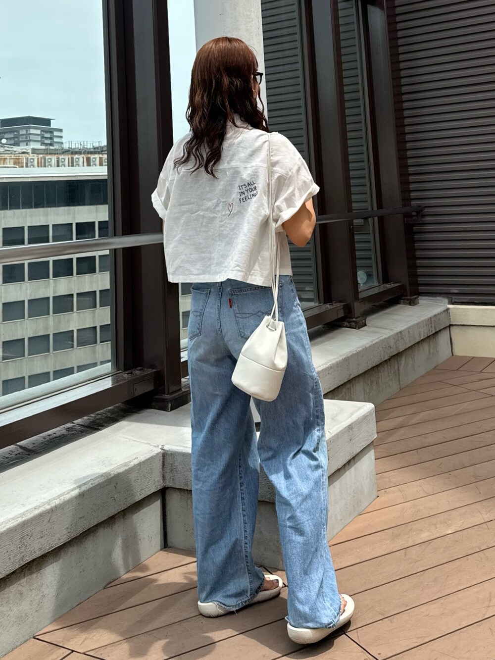 ブルー系のデニムパンツ、グレー系のTシャツ/カットソー、ホワイト系のシャツ/ブラウスを着用したレディースの夏コーディネートの5枚目の写真