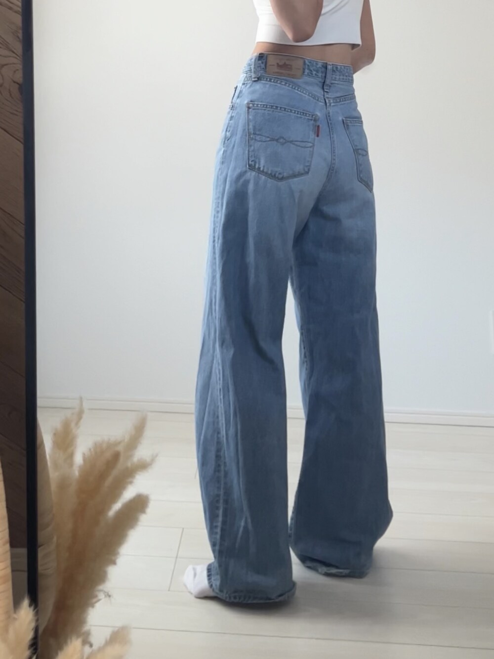 ブルー系のデニムパンツ、ブラック系のベルト、ブラック系のニットキャップ/ビーニーを着用したレディースの秋コーディネートの5枚目の写真