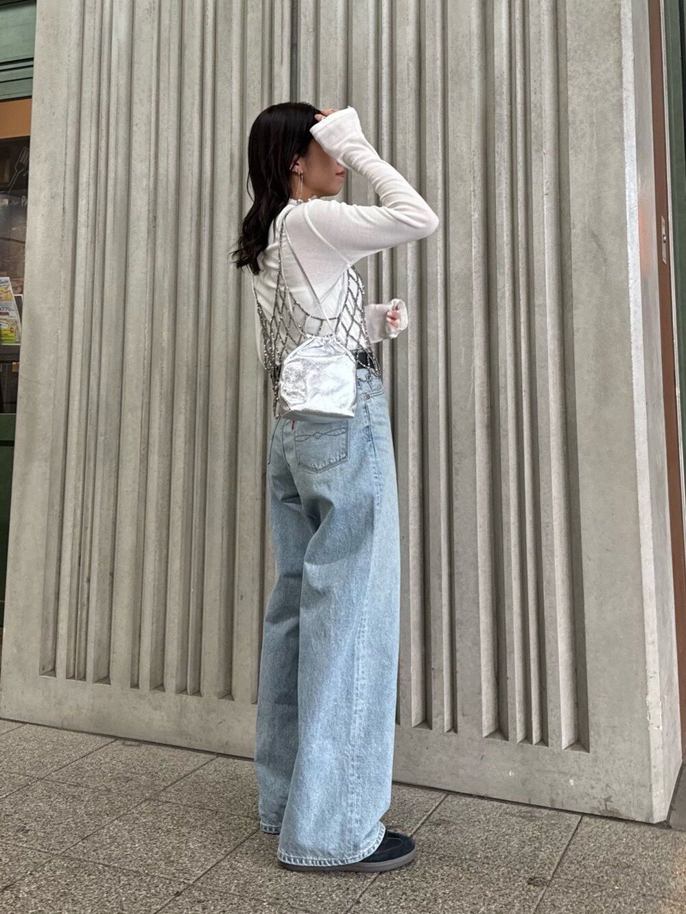 ブラック系のベスト、ブルー系のデニムパンツ、ホワイト系のTシャツ/カットソーを着用したレディースの冬コーディネートの2枚目の写真