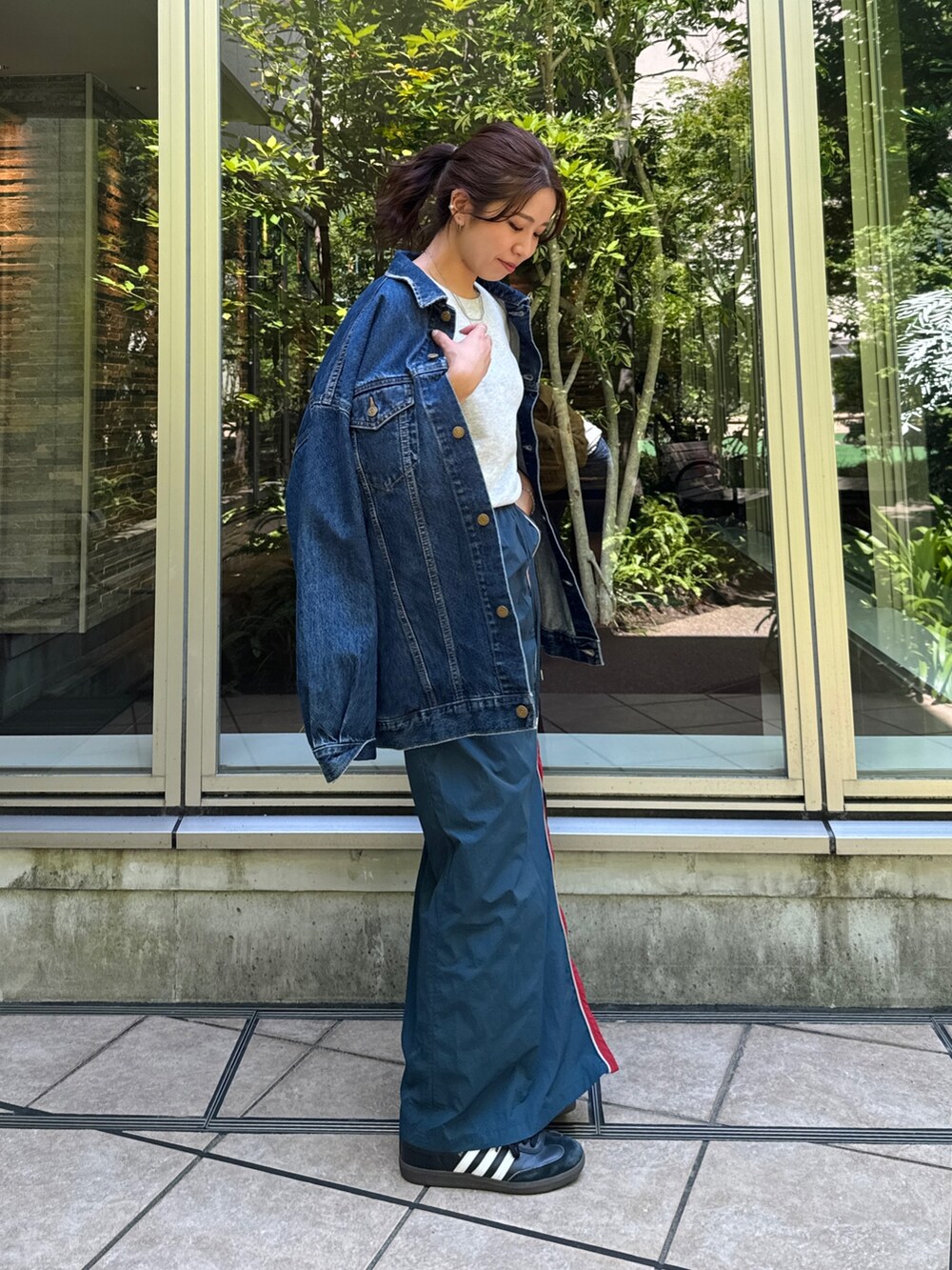 ブルー系のスカート、グレー系のスウェット、ブルー系のデニムジャケットを着用したレディースの夏コーディネートの3枚目の写真