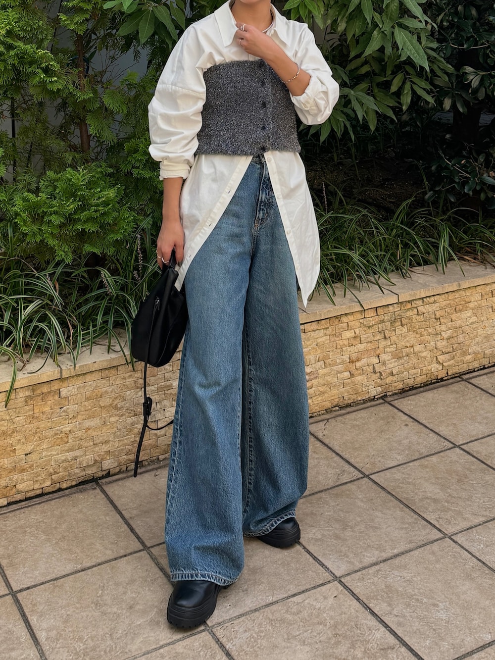 ブルー系のデニムパンツ、ホワイト系のシャツ/ブラウス、ブラック系のニット/セーターを着用したレディースの秋コーディネートの2枚目の写真