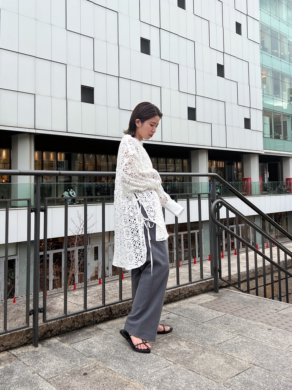 ホワイト系のシャツ/ブラウス、グレー系のその他パンツ、ブラック系のサンダルを着用したレディースの春コーディネートの4枚目の写真