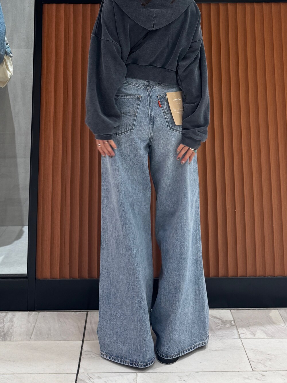 ブルー系のデニムパンツ、グレー系のパーカー、ブラック系のスリッポンを着用したレディースの秋コーディネートの6枚目の写真