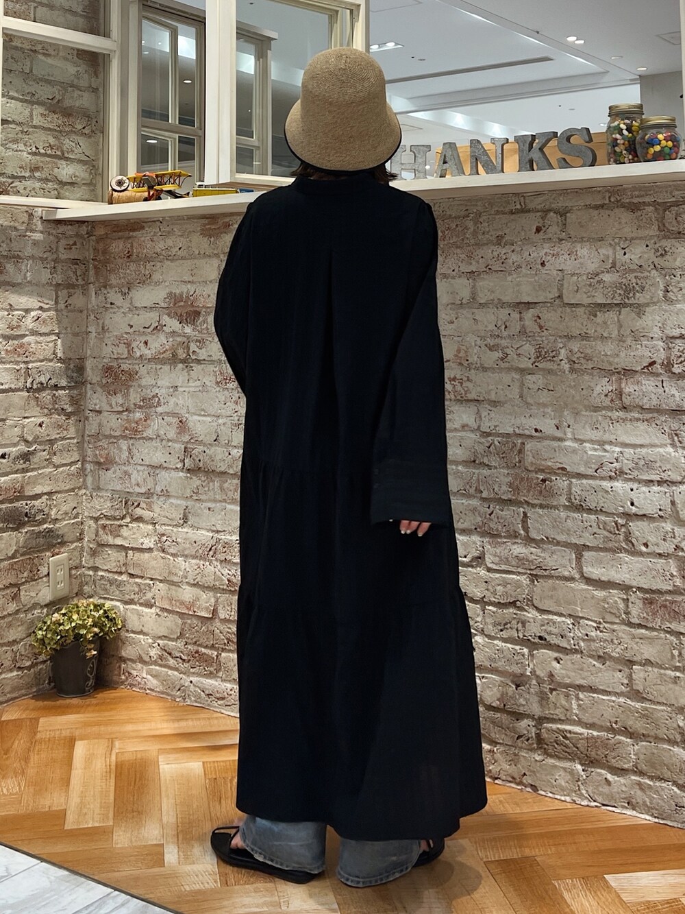 ブルー系のデニムパンツ、ブラック系のサンダル、ブラック系のワンピースを着用したレディースの春コーディネートの4枚目の写真