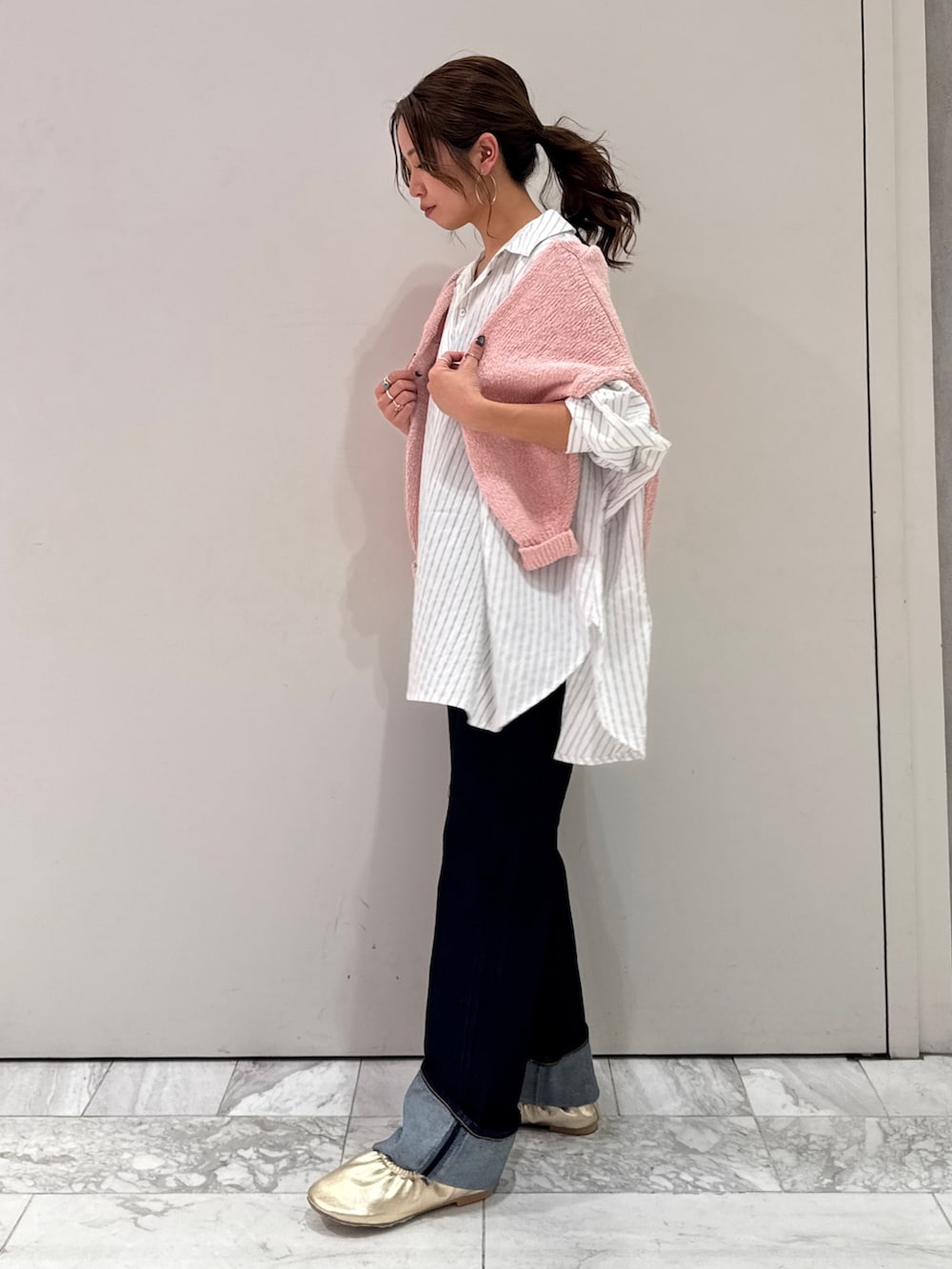 ブルー系のデニムパンツ、ホワイト系のシャツ/ブラウス、ピンク系のニット/セーターを着用したレディースの冬コーディネートの6枚目の写真