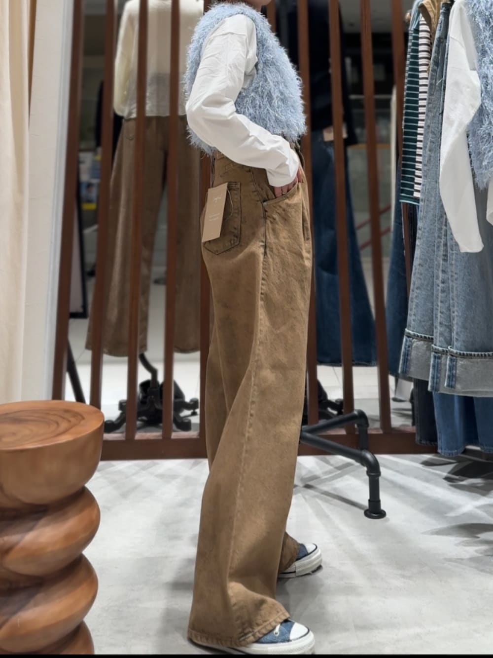 ブラウン系のデニムパンツ、ブルー系のニット/セーター、ホワイト系のTシャツ/カットソーを着用したレディースの春コーディネートの4枚目の写真