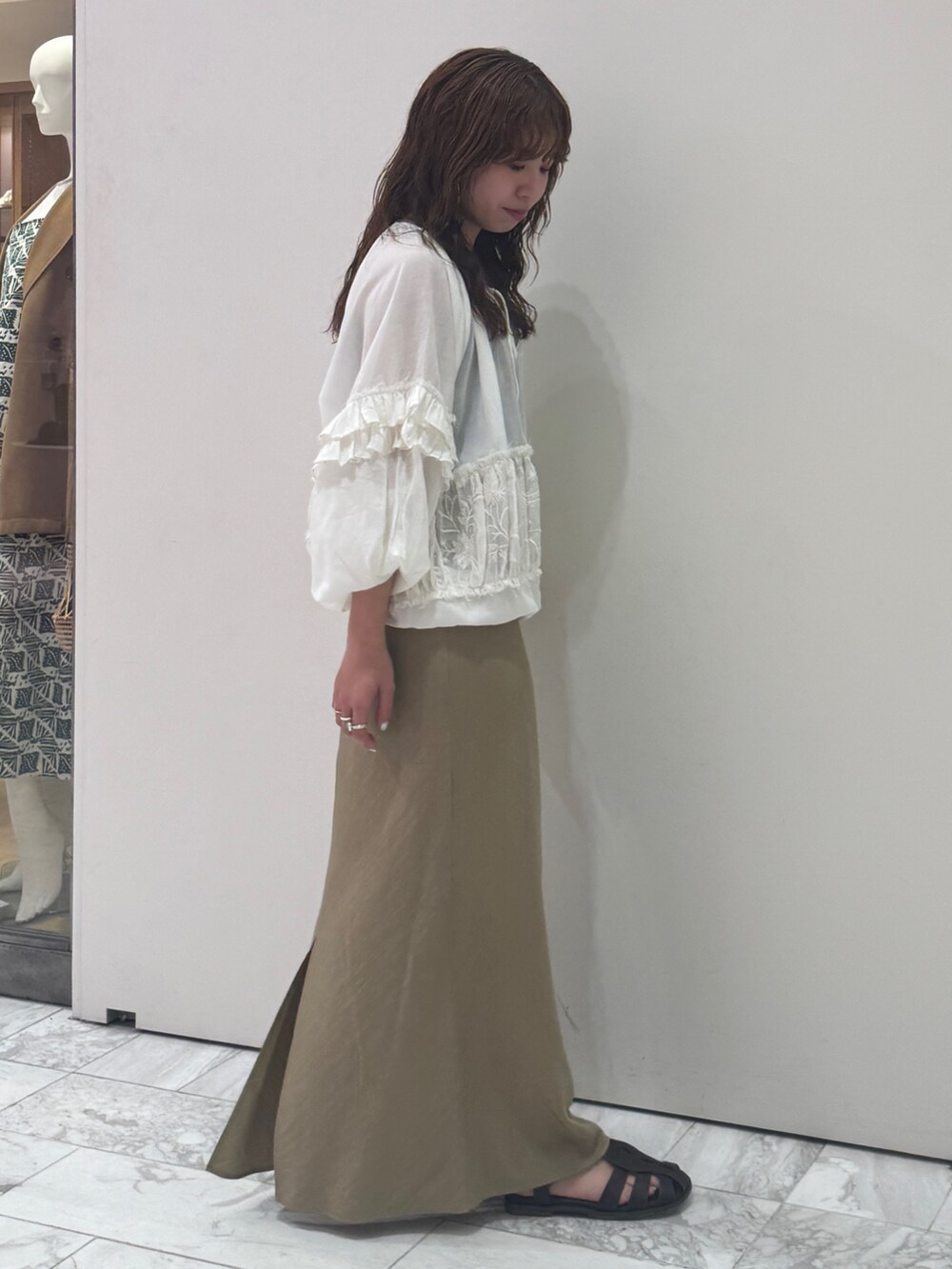 ベージュ系のスカート、ホワイト系のシャツ/ブラウス、ブラック系のキャミソールを着用したレディースの春コーディネートの3枚目の写真