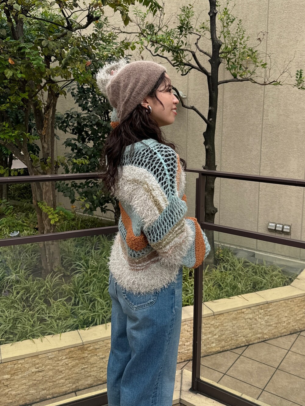 ブルー系のニット/セーター、ブラック系のTシャツ/カットソー、ブルー系のデニムパンツを着用したレディースの秋コーディネートの8枚目の写真