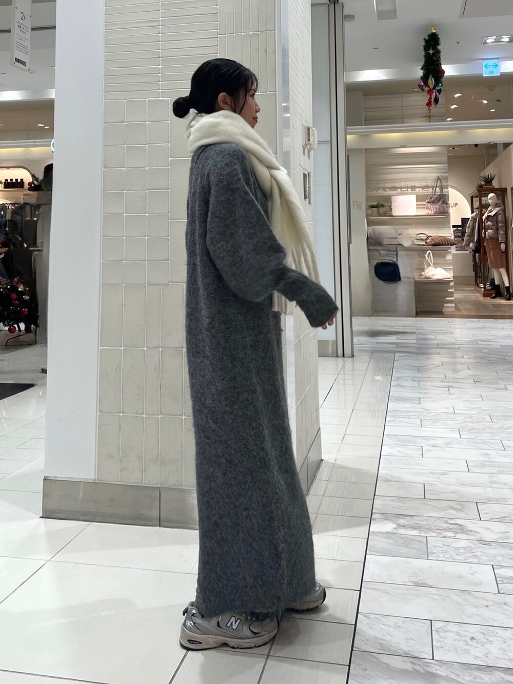 グレー系のワンピース、グリーン系のショルダーバッグ、ホワイト系のマフラーを着用したレディースの秋コーディネートの5枚目の写真