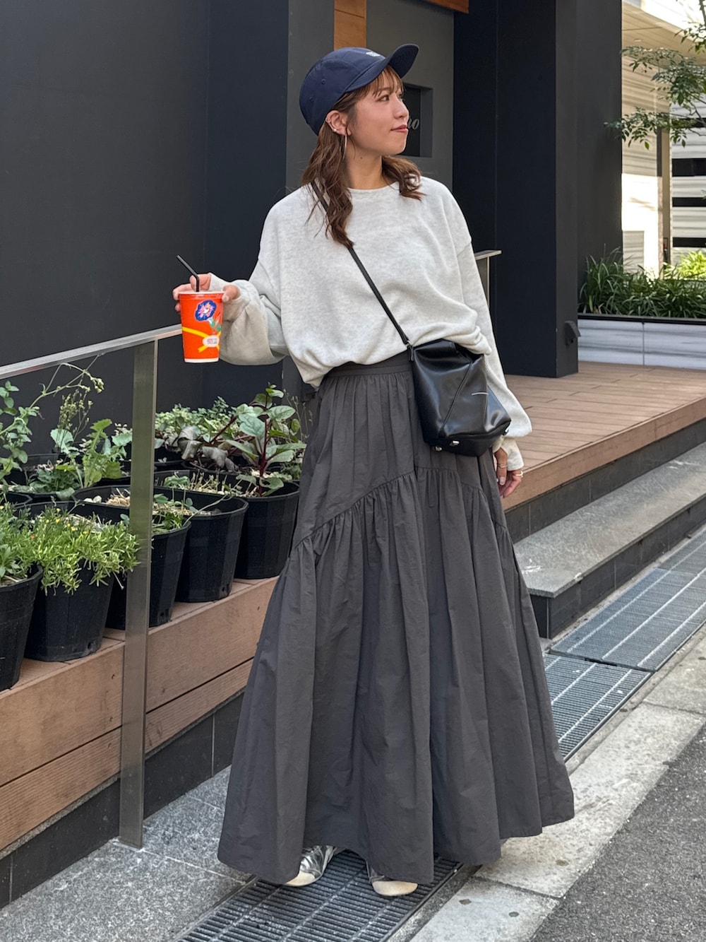 グレー系のスカート、ホワイト系のTシャツ/カットソー、ブルー系のキャップを着用したレディースの夏コーディネートの3枚目の写真