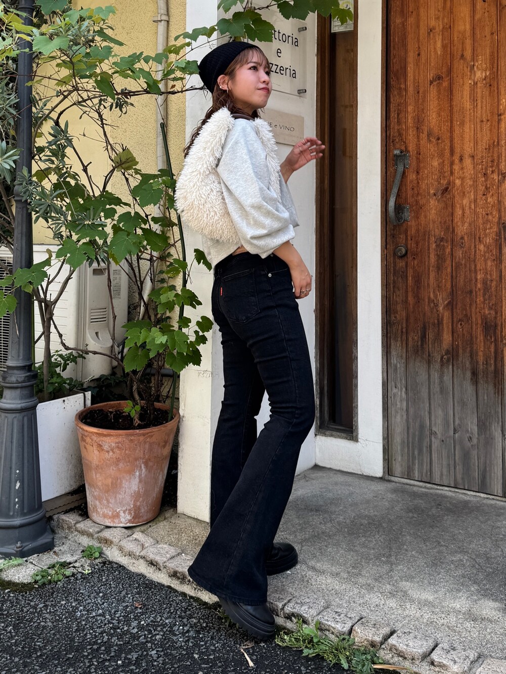 ブラック系のデニムパンツ、グレー系のスウェット、ホワイト系のハンドバッグを着用したレディースの夏コーディネートの2枚目の写真