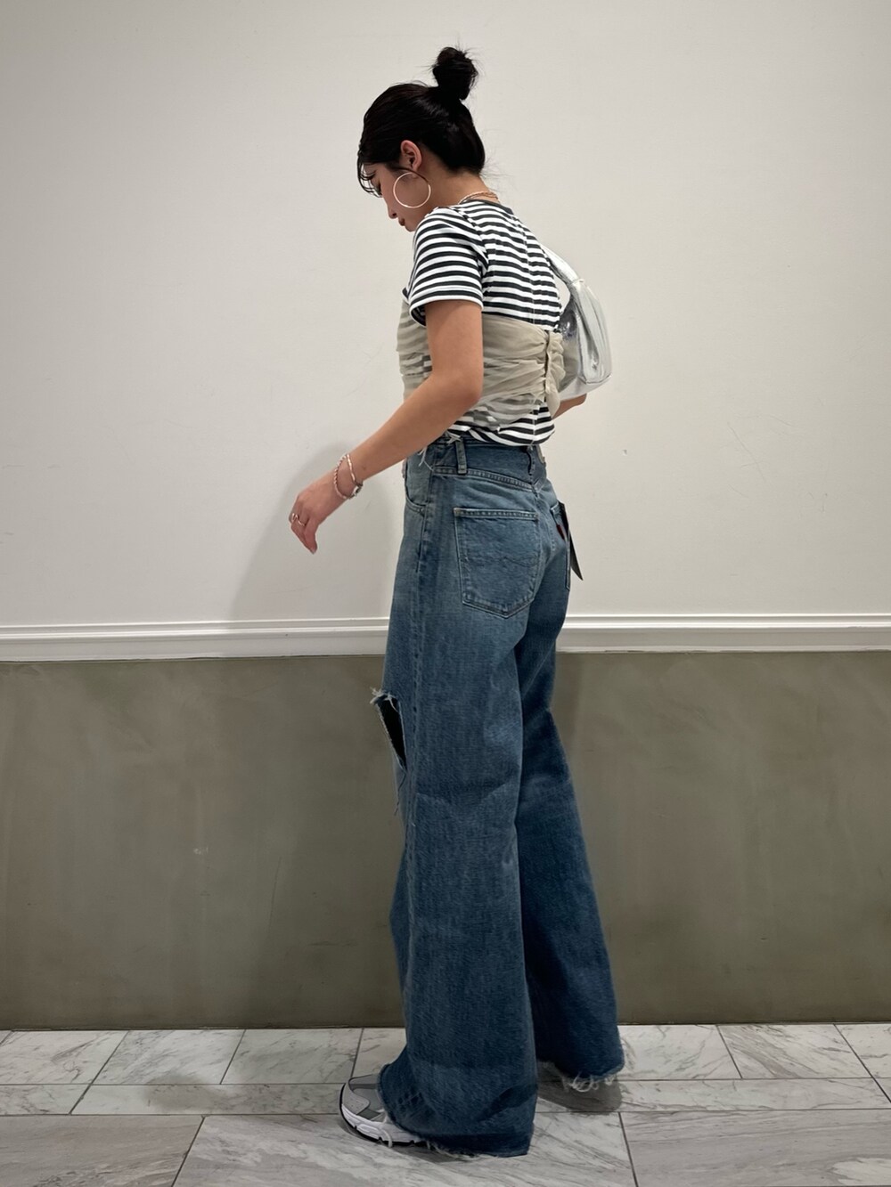 グレー系のTシャツ/カットソー、ベージュ系のキャミソール、ブルー系のデニムパンツを着用したレディースの春コーディネートの8枚目の写真