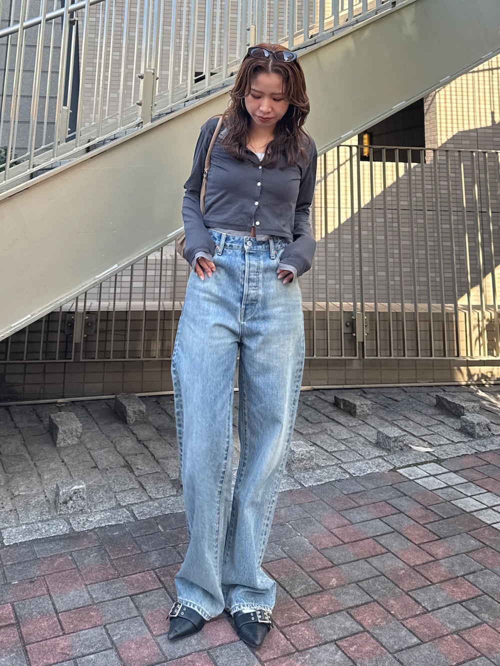 ブルー系のデニムパンツ、グレー系のカーディガン/ボレロを着用したレディースの冬コーディネートの2枚目の写真