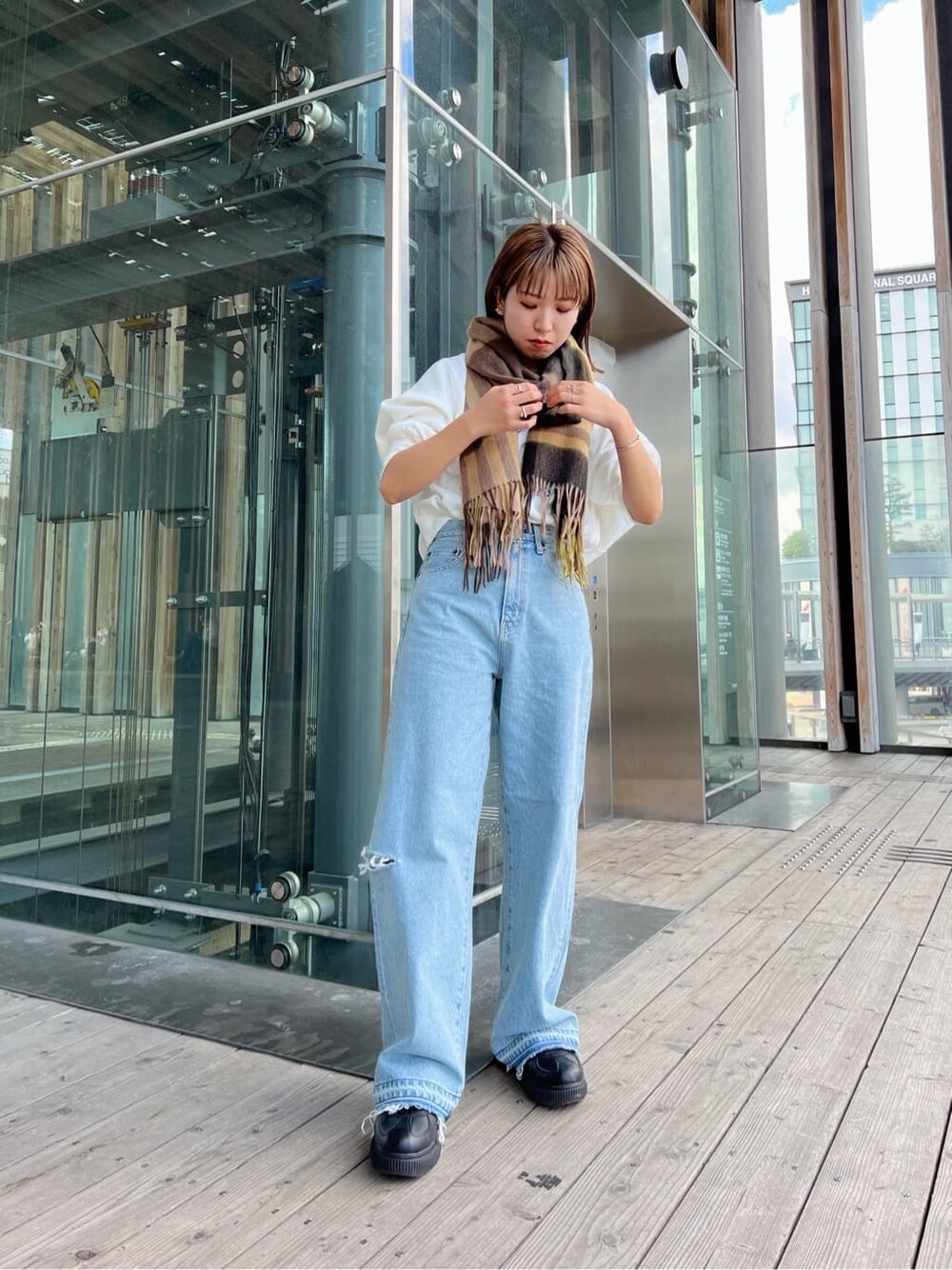 ブルー系のデニムパンツ、ブルー系のデニムパンツ、ホワイト系のスウェットを着用したレディースの秋コーディネートの3枚目の写真