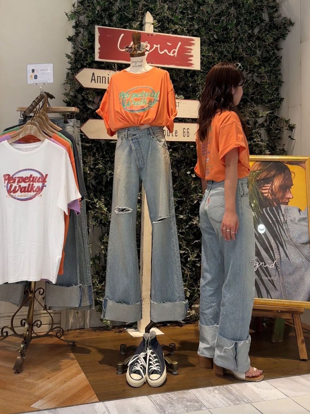 ブルー系のデニムパンツ、オレンジ系のTシャツ/カットソー、ホワイト系のサンダルを着用したレディースの夏コーディネートの4枚目の写真