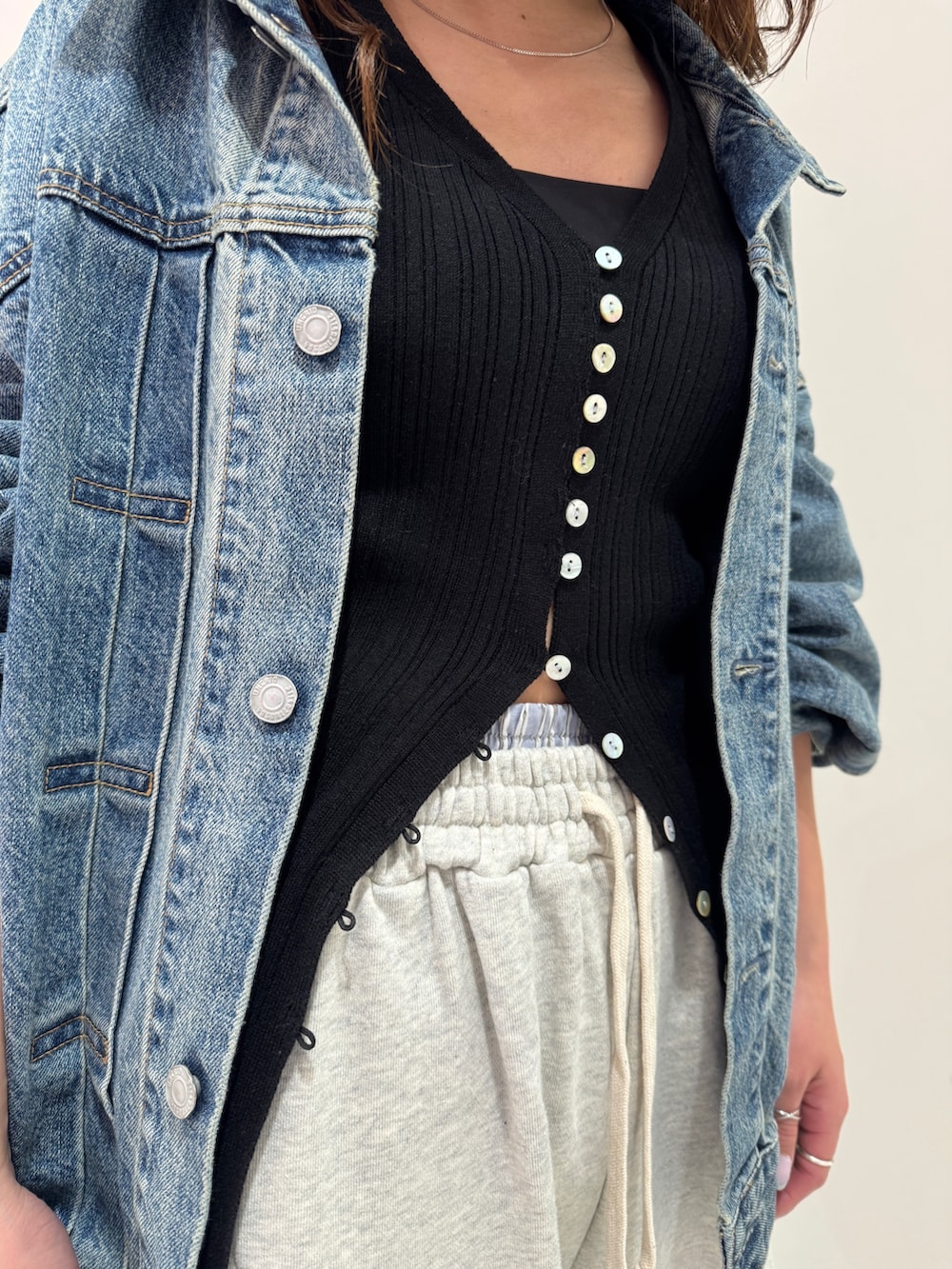 ブルー系のデニムジャケット、ブラック系のカーディガン/ボレロ、ホワイト系のスウェットパンツを着用したレディースの冬コーディネートの8枚目の写真