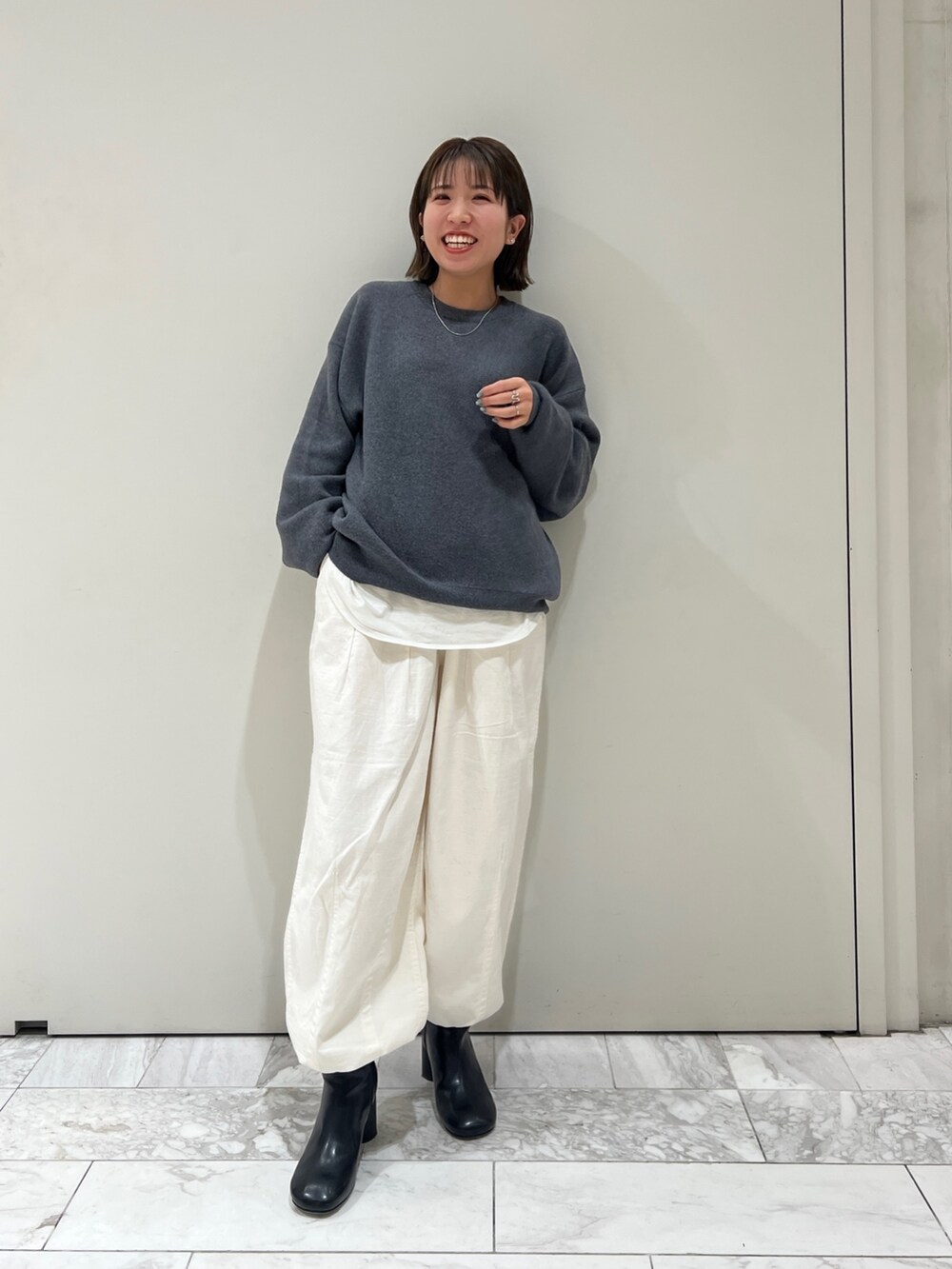 グレー系のニット/セーター、ホワイト系のTシャツ/カットソー、ホワイト系のその他パンツを着用したレディースの冬コーディネートの3枚目の写真