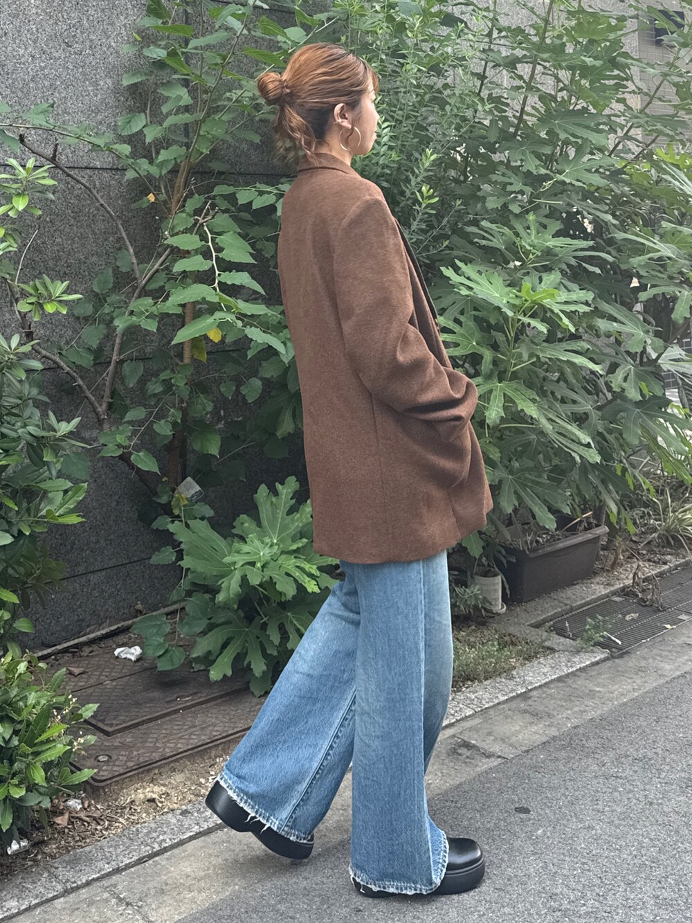 ブラウン系のテーラードジャケット、ブルー系のデニムパンツを着用したレディースの秋コーディネートの3枚目の写真