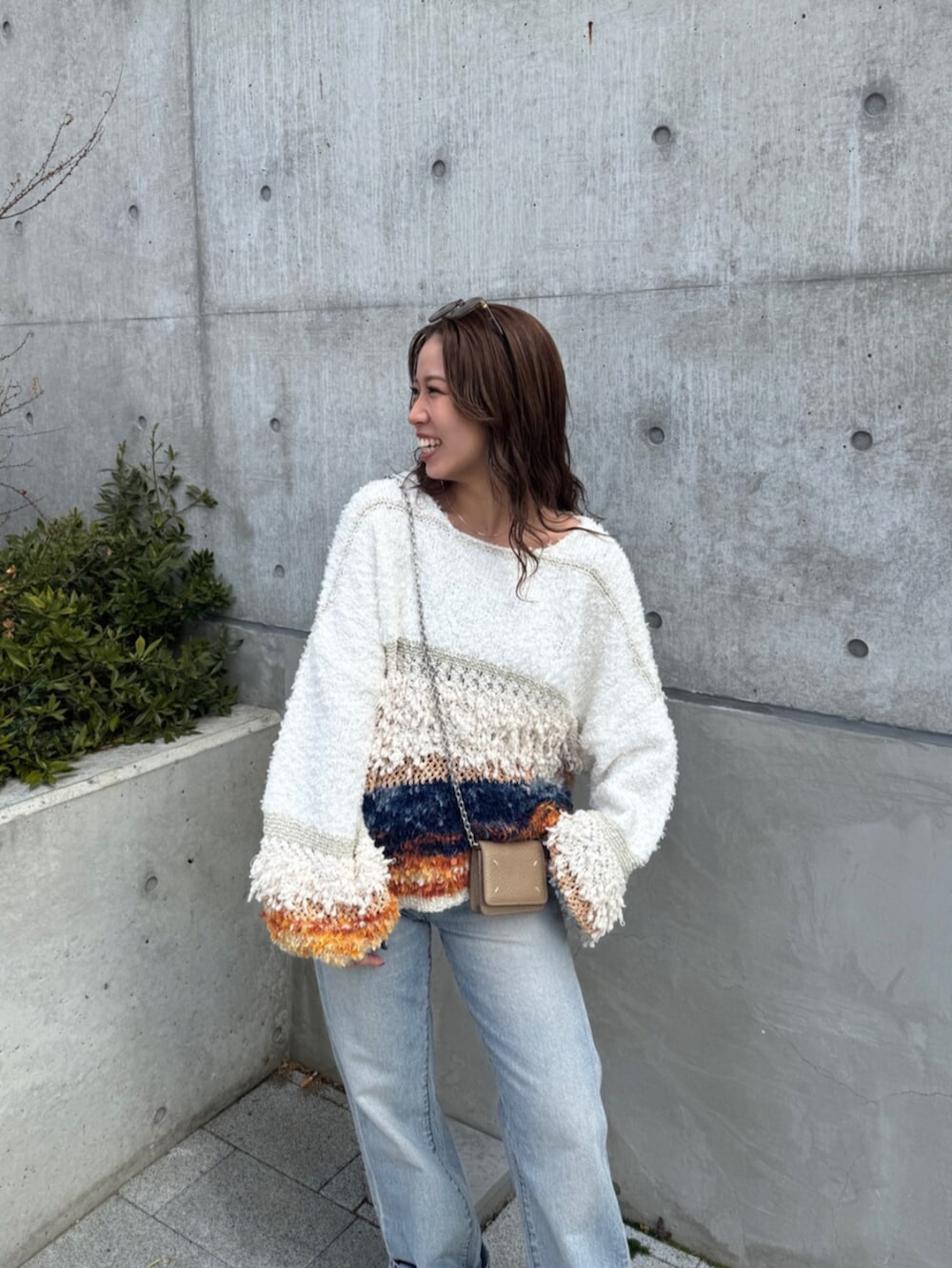 ブルー系のデニムパンツ、ホワイト系のニット/セーター、ブラウン系のスニーカーを着用したレディースの冬コーディネートの8枚目の写真