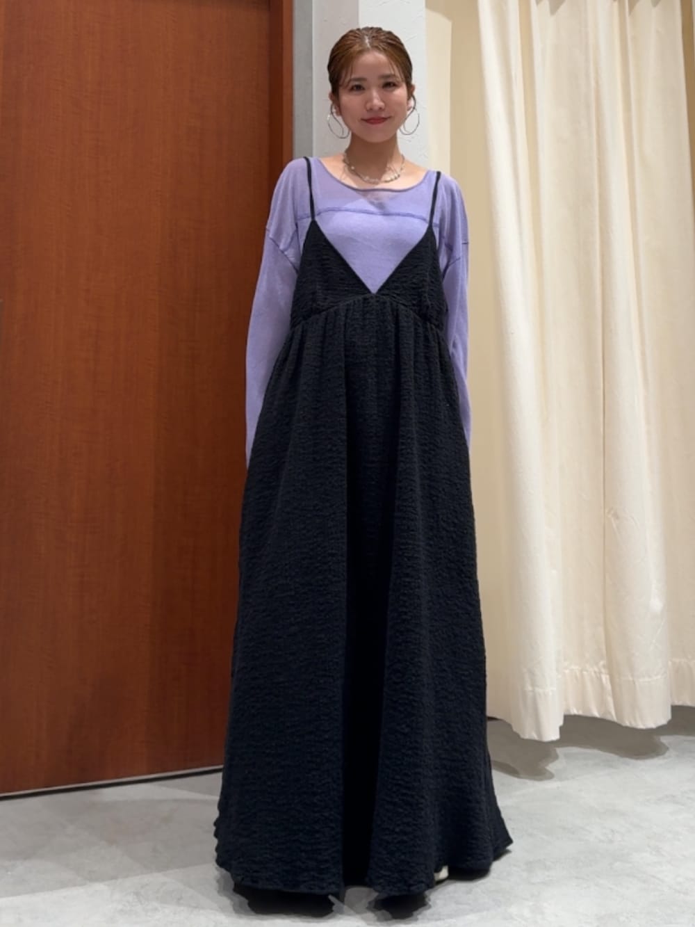 ブラック系のワンピース、パープル系のニット/セーター、ブルー系のデニムパンツを着用したレディースの春コーディネートの6枚目の写真