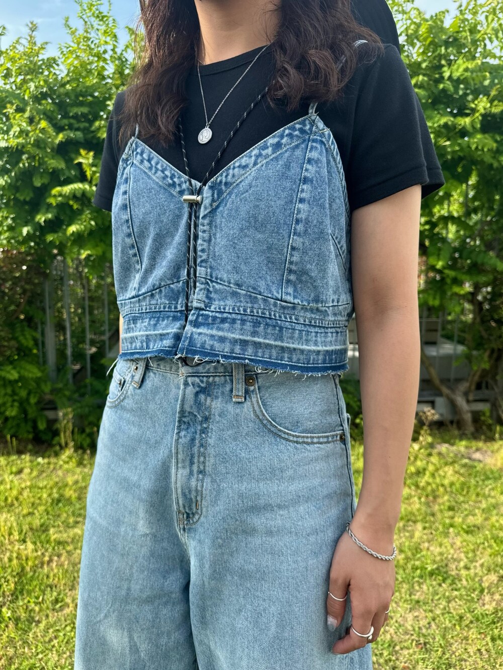 ブルー系のキャミソール、ブルー系のデニムパンツ、ブラック系のTシャツ/カットソーを着用したレディースの夏コーディネートの5枚目の写真